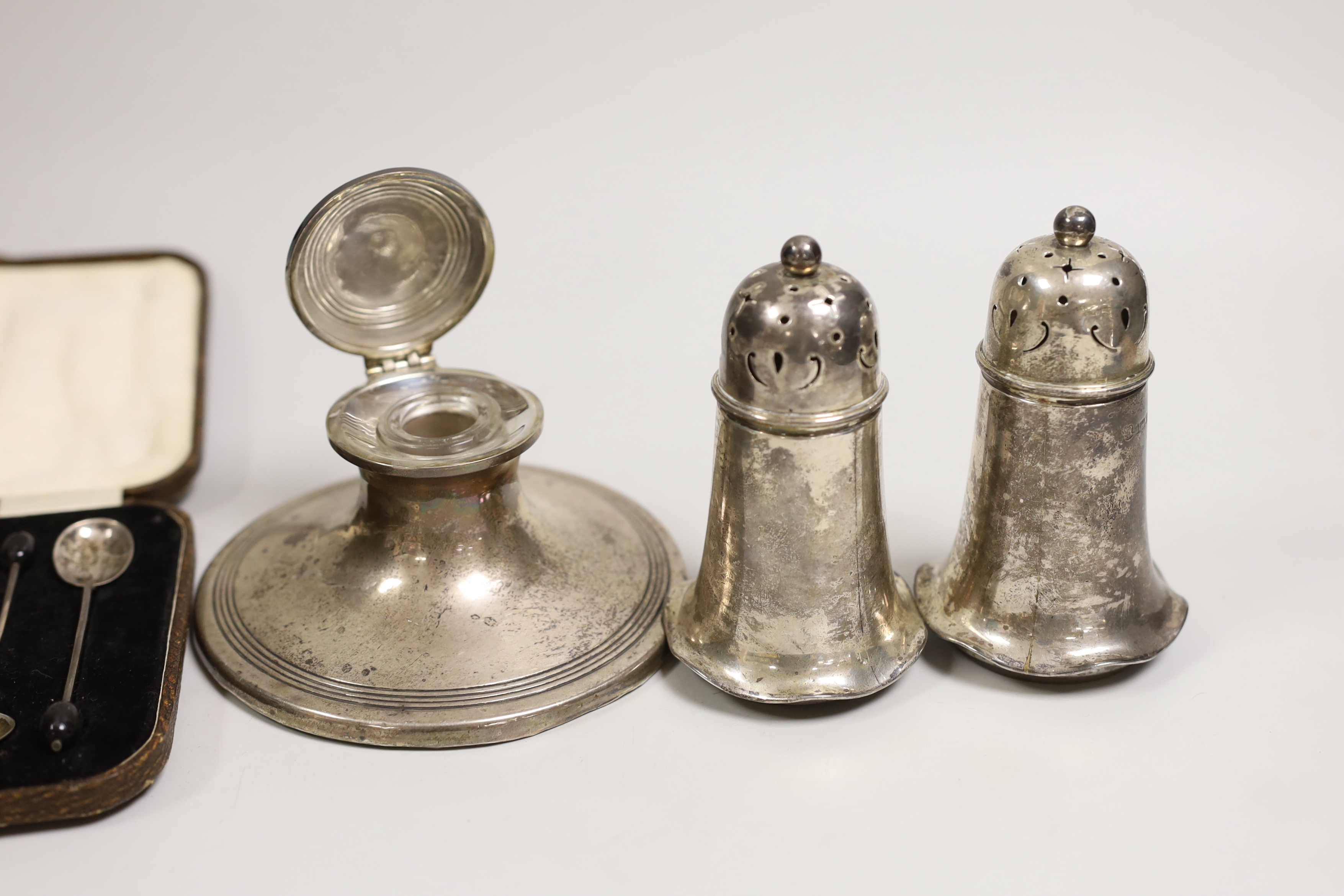 A pair of Edwardian silver sugar casters, Sheffield, 1907, 11.2cm, a silver mounted capstan inkwell and cased set of six silver bean end coffee spoons.